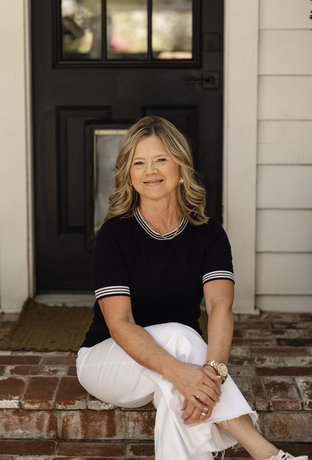 Darla Nelson sitting on a porch step, a quiet, candid moment