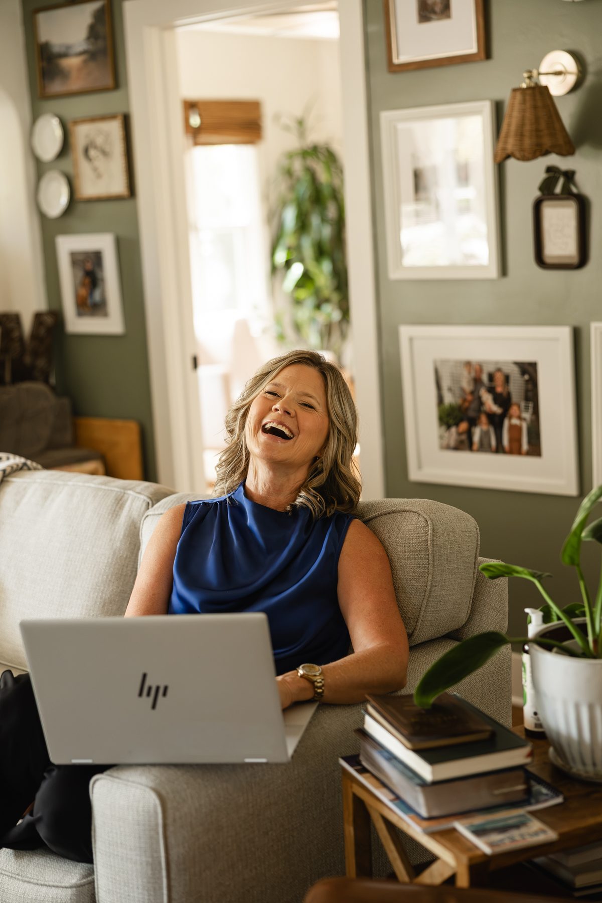 Darla Nelson laughing on her couch with her laptop